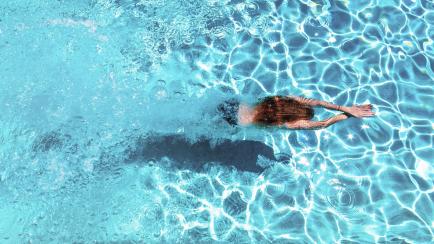 Una mujer nadando en una piscina.