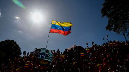 TOPSHOT - Supporters of Venezuelan President Nicolas Maduro shout slogans at the Miraflores Palace in Caracas to support the state-owned CONVIASA airline during a protest against the sanctions imposed by the US government, on February 10, 2020. ...