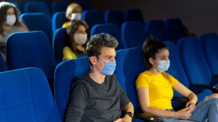 Group of people watching movie in the cinema after Coronavirus loosening measures.