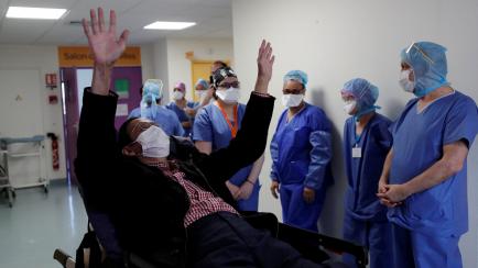 Medical staff members surround patient Mang Phother, 61, who spent 16 days in the Intensive Care Unit (ICU) for the coronavirus disease (COVID-19), as he leaves the Clinique de l'Estree private hospital in Stains near Paris as the spread of the ...