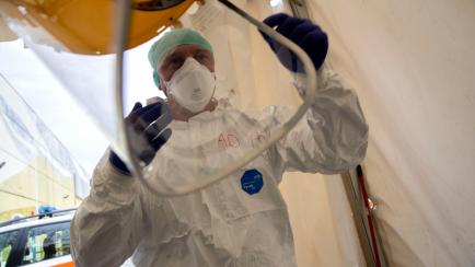 El enfermero Abramo Pozzaglio pone equipo protector en una de las estructuras de emergencia que fueron montados para facilitar los procesos de la llegada de pacientes de COVID-19 en el Hospital Civil Spedali, en Brescia, Italia, el viernes 27 de...