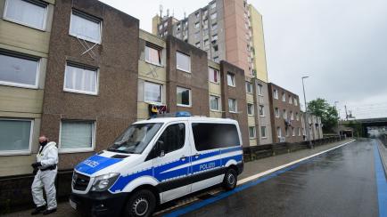 18 June 2020, Lower Saxony, Göttingen: Police officers in protective gear are standing outside a residential building. In view of about 100 new coronavirus infections in the high-rise building, the building complex has been completely quarantin...