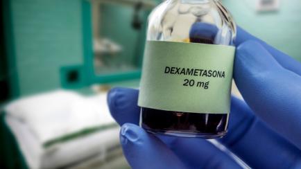 Doctor holds vial of dexamethasone in an operating theater, conceptual image