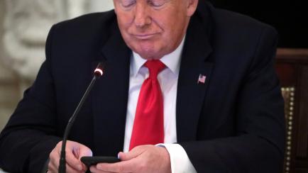 WASHINGTON, DC - JUNE 18: U.S. President Donald Trump looks at his phone during a roundtable at the State Dining Room of the White House June 18, 2020 in Washington, DC. President Trump held a roundtable discussion with Governors and small busin...