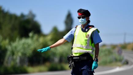 A member of the Catalan regional police force Mossos d'Esquadra controls a checkpoint on the Corbins highway near Lleida on July 4, 2020. - Spain's northeastern Catalonia region locked down an area with around 200,000 residents around the town o...