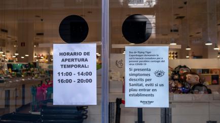Carteles a la puerta de una tienda en Barcelona.