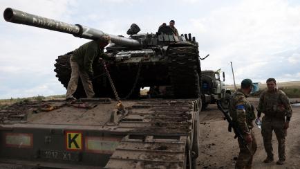 Un tanque ruso T-72 es cargado en un camión por soldados ucranianos en las afueras de la ciudad de Izyum. 