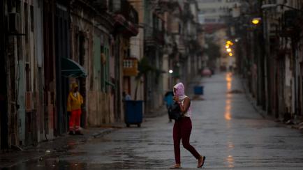 Un peatón cruza una calle vacía durante el paso del huracán Ian en La Habana: