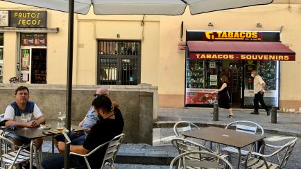 Tres hombres este jueves en una terraza de Madrid, próxima al Museo Reina Sofía, junto a un estanco.