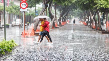 Varias personas intentan resguardarse de un temporal reciente