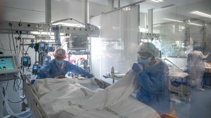Sanitarios asisten a un paciente de covid en la UCI del Hospital Clinic de Barcelona.
