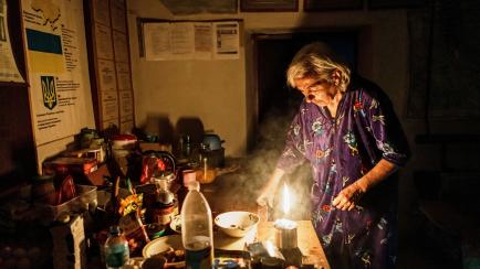 Una ucraniana ilumina su casa con una vela el pasado junio