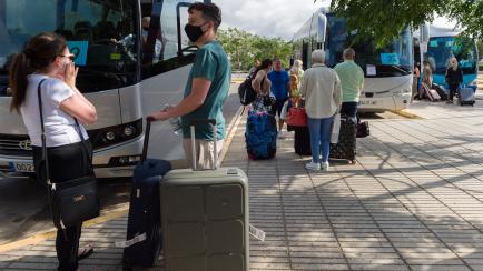 Varios turistas, frente a un autobús en Ibiza el 30 de junio.