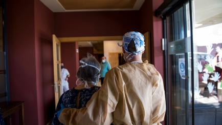 Un trabajador acompaña a una mujer mayor a la zona de visitas en una residencia de Granada, el 1 de junio de 2020.