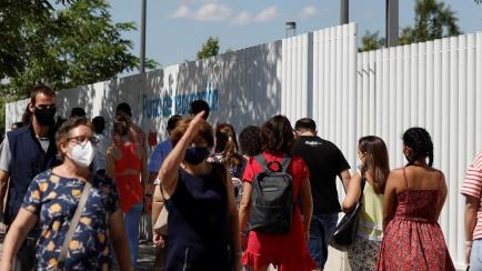 Ciudadanos al sol mientras esperan a la entrada del Hospital Isabel Zendal