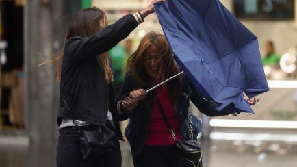 Una mujer con el paraguas roto en Madrid.