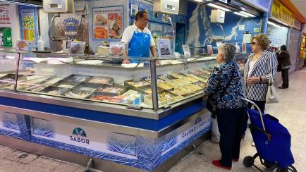 Jesús, de Congelados J. Romero, atendiendo a unas clientas en el mercado de Vicálvaro (Madrid).