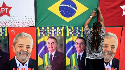 Un vendedor expone toallas con los rostros de Lula da Silva y Bolsonaro, el pasado 25 de octubre, en Belo Horizonte, Brasil. 