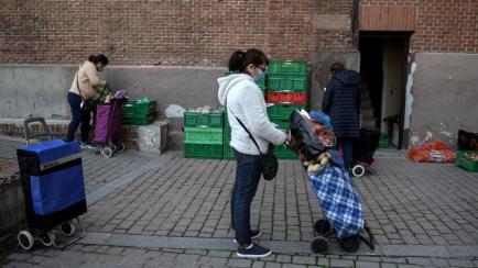Una mujer espera para recibir comida en Madrid, el pasado 10 de marzo.