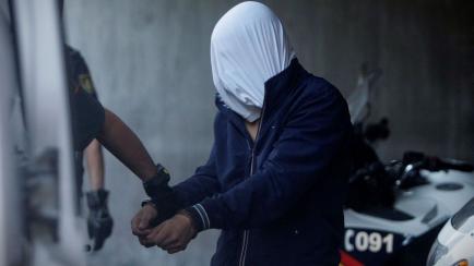 Agentes de la Guardia Civil conducen a uno de los cuatro detenidos por el homicidio de Samuel Luiz al interior de los juzgados de la Coruña. /