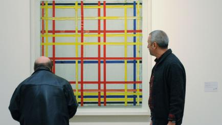 Dos hombres observan el cuadro 'New York City 1' de Piet Mondrian en una exposición en el museo de Colonia, Alemania. 