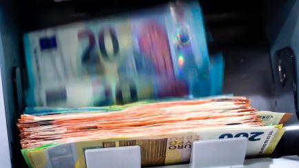 Imagen de archivo de una máquina contando billetes de euro.