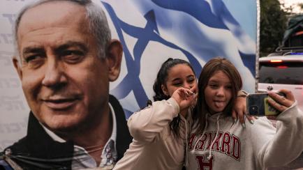 Unas chicas posan ante un autobús de campaña de Benjamín Netanyahu, el pasado 23 de octubre, en Migdal HaEmek (Israel).