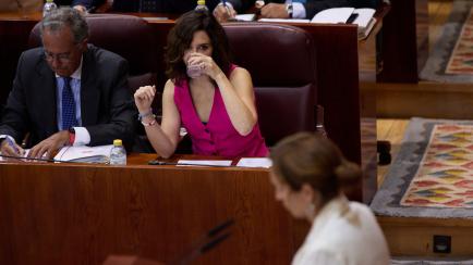Mónica García, desde la tribuna de la Asamblea mientras Ayuso echa un trago de agua