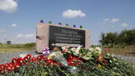 Locales depositan flores en el monumento en memoria de las víctimas del vuelo Malaysia Airlines MH17 derribado en 2014.