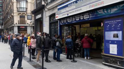 Varias personas esperan su turno en la administración de la lotería Doña Manolita, en Madrid. 