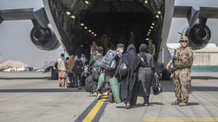 Los marines de EEUU vigilan el embarque de refugiados afganos, en el aeropuerto de Kabul. 