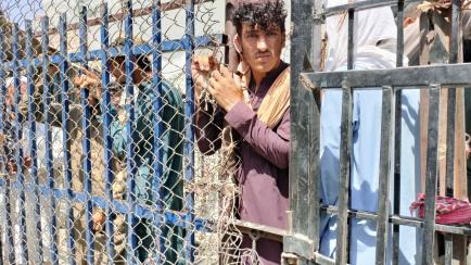 Un hombre afgano espera, junto con otras personas, en el puesto fronterizo de Torkham para cruzar a Pakistán desde Afganistán, el 2 de septiembre de 2021.