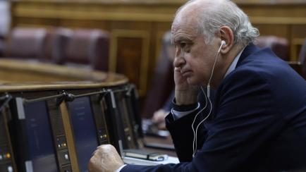 Jorge Fernández Díaz, escuchando algo con unos auriculares. 