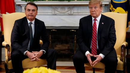President Donald Trump listens as Brazilian President Jair Bolsonaro speaks during a meeting in the Oval Office of the White House, Tuesday, March 19, 2019, in Washington. (AP Photo/Evan Vucci)