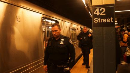 Agentes patrullan el interior del metro en Manhattan tras el tiroteo en Brooklyn