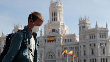 Un hombre camina con mascarilla frente al Ayuntamiento de Madrid