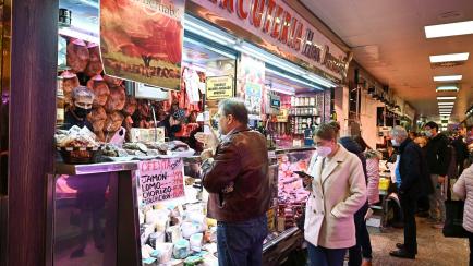 Un par de clientes con y sin mascarilla visitan un mercado de Madrid.