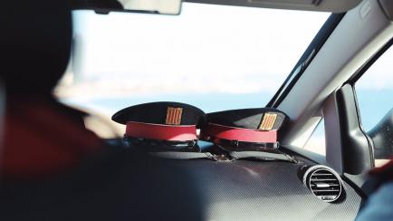 Dos gorras en un vehí­culo de Mossos d'Esquadra. ARCHIVO.