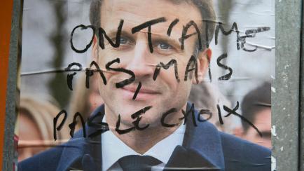 Pintada sobre un cartel electoral de Emmanuel Macron que dice: "No te queremos, pero no tenemos otra opción", este 24 de abril, en Saint-Denis.