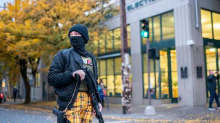 PORTLAND, OR - NOVEMBER 04:  An armed protester stands guard as a Defend Democracy rally passes the Multnomah County Elections Office on November 4, 2020 in Portland, Oregon. Multiple protests, some peaceful and others violent, broke out in Port...