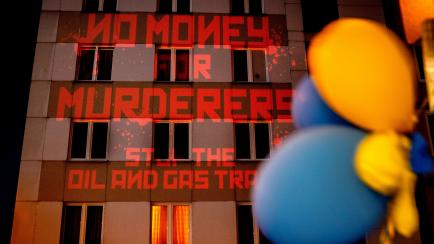 "No más dinero a asesinos. Parad los tratados de petróleo y gas", se lee en la fachada de un edificio, durante una protesta proUcrania en Frankfurt (Alemania), el 4 de abril. 