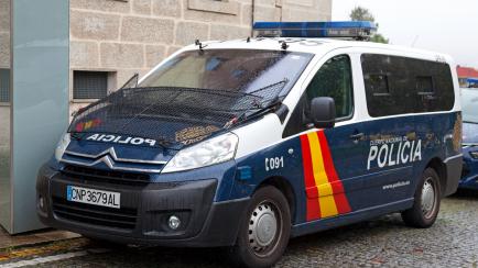 Santiago de Compostela, Spain - June 05 2018: A police van from the national police (Spanish: Policía Nacional) parked under the rain outside the police station.