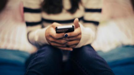 Imagen de archivo de una adolescente utilizando un teléfono móvil.