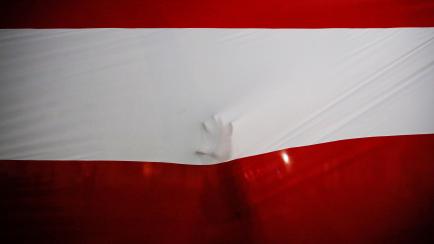 A person touches the national flag after Francisco Sagasti from the Centrist Morado Party was elected Peru's interim president by Congress, in Lima, Peru November 16, 2020. REUTERS/Sebastian Castaneda     TPX IMAGES OF THE DAY