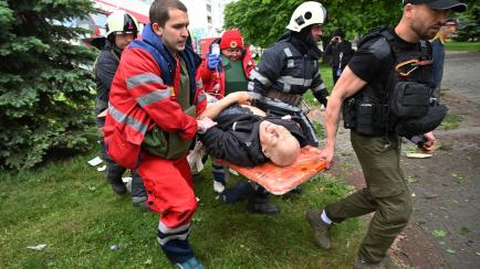 Paramédicos cargan a un hombre herido en Jarkov.