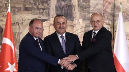 Los responsables de Exteriores turco, rumano y polaco, este viernes.