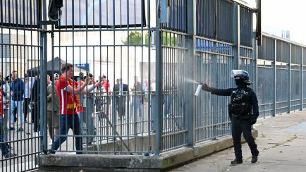 Un agente de la Policía francesa rocía a los aficionados del Liverpool a las afueras del Stade de France. 