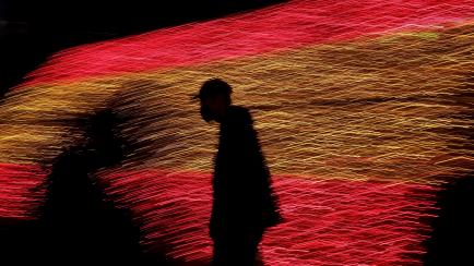 Un hombre camina el pasado 26 de noviembre en Madrid con las luces de Navidad que forman la bandera de España.