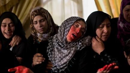 Una mujer llora, manchada por la sangre de su hermano muerto por tropas israelíes, en Hebrón, Cisjordania, en 2013. 