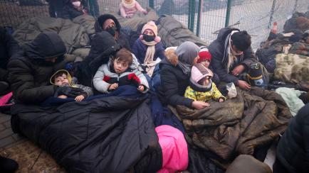 Un grupo de migrantes se protege del frío con mantas en la frontera entre Bielorrusia y Polonia. 